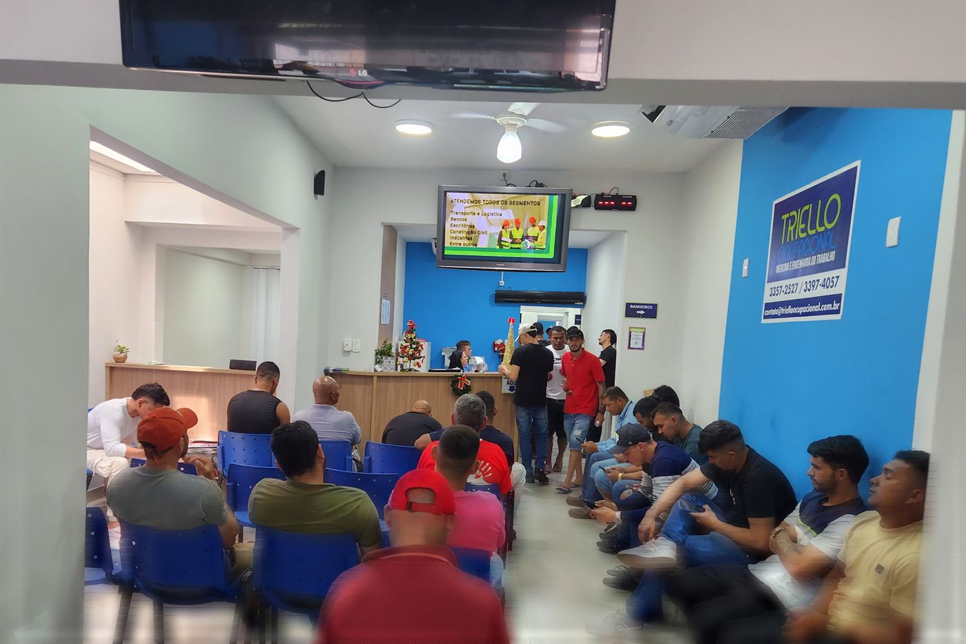 Recepção da clínica, com o painel da Triello na parede e o balcão de atendimento ao fundo.
